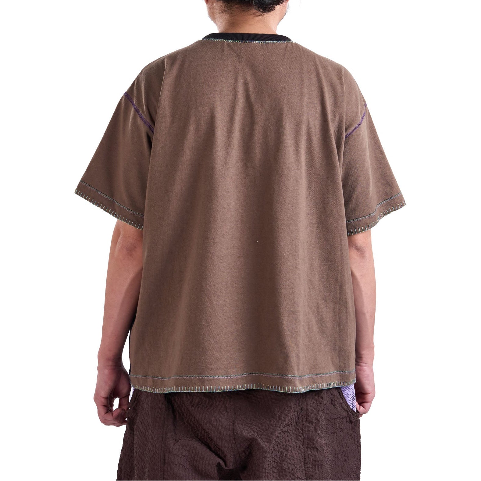Person wearing a brown shirt and pants on a white background