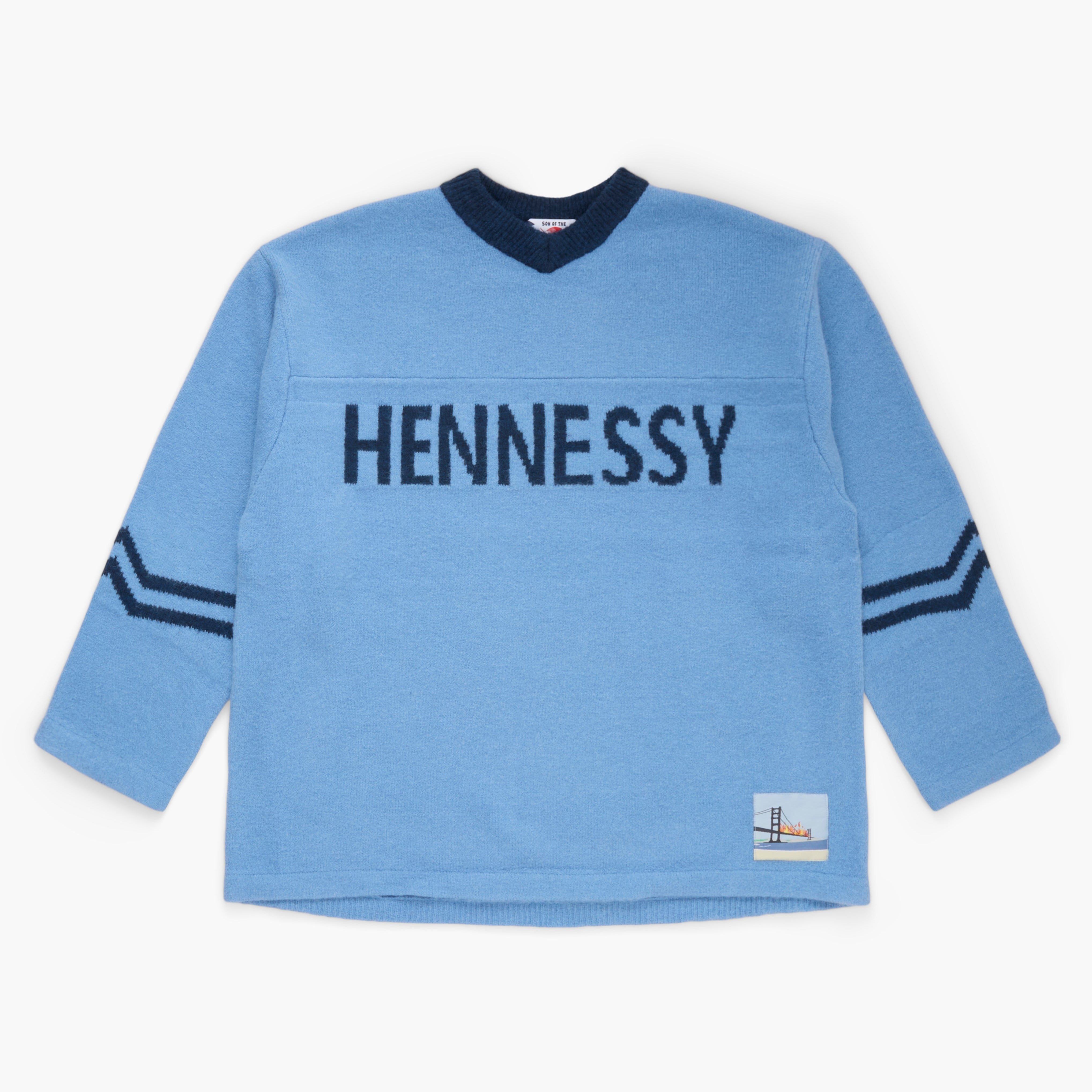 Blue sweater with 'Hennessy' knit on the front on a white background