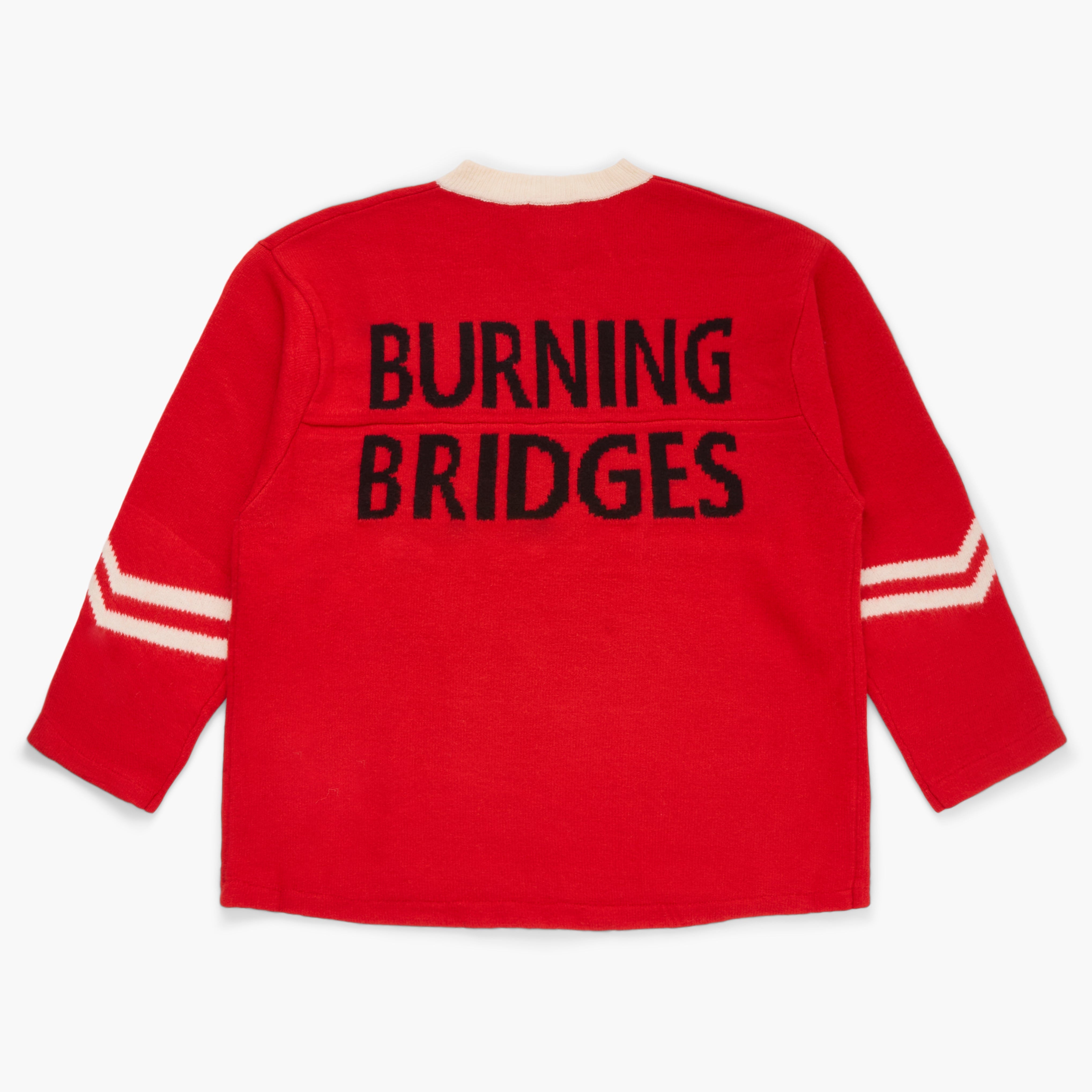 Red sweater with 'Burning Bridges' knit at the back on a white background