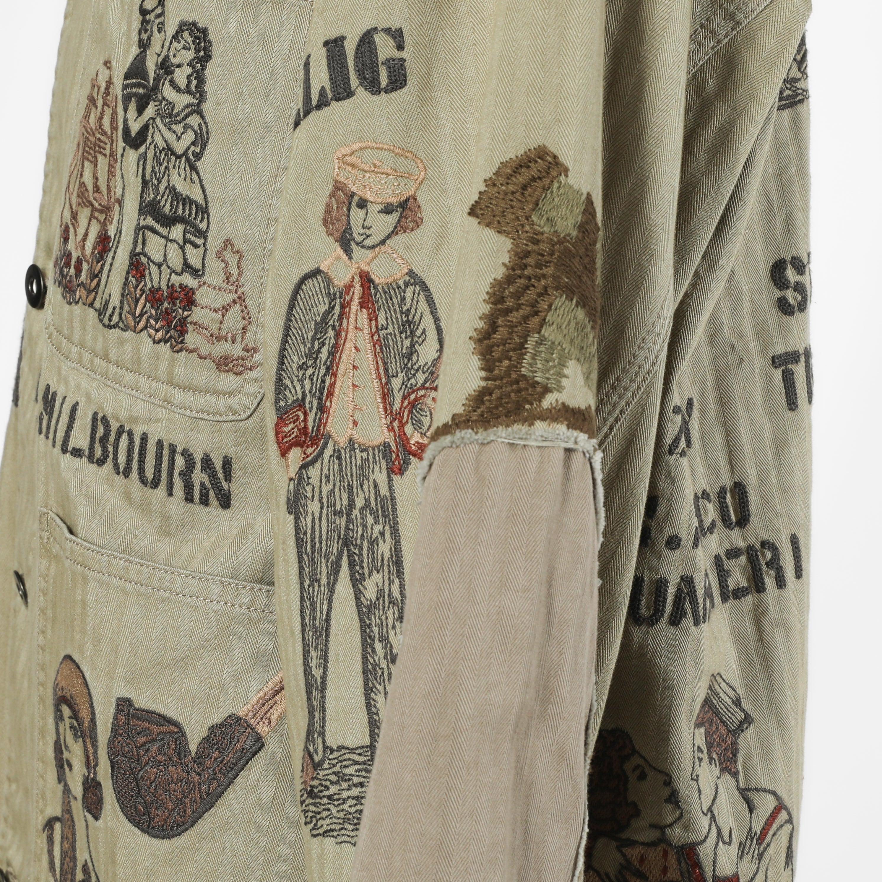 Close-up of a beige canvas jacket with a vintage-style illustrated print featuring figures, a smoking pipe, and text including 'MILBOURN'.