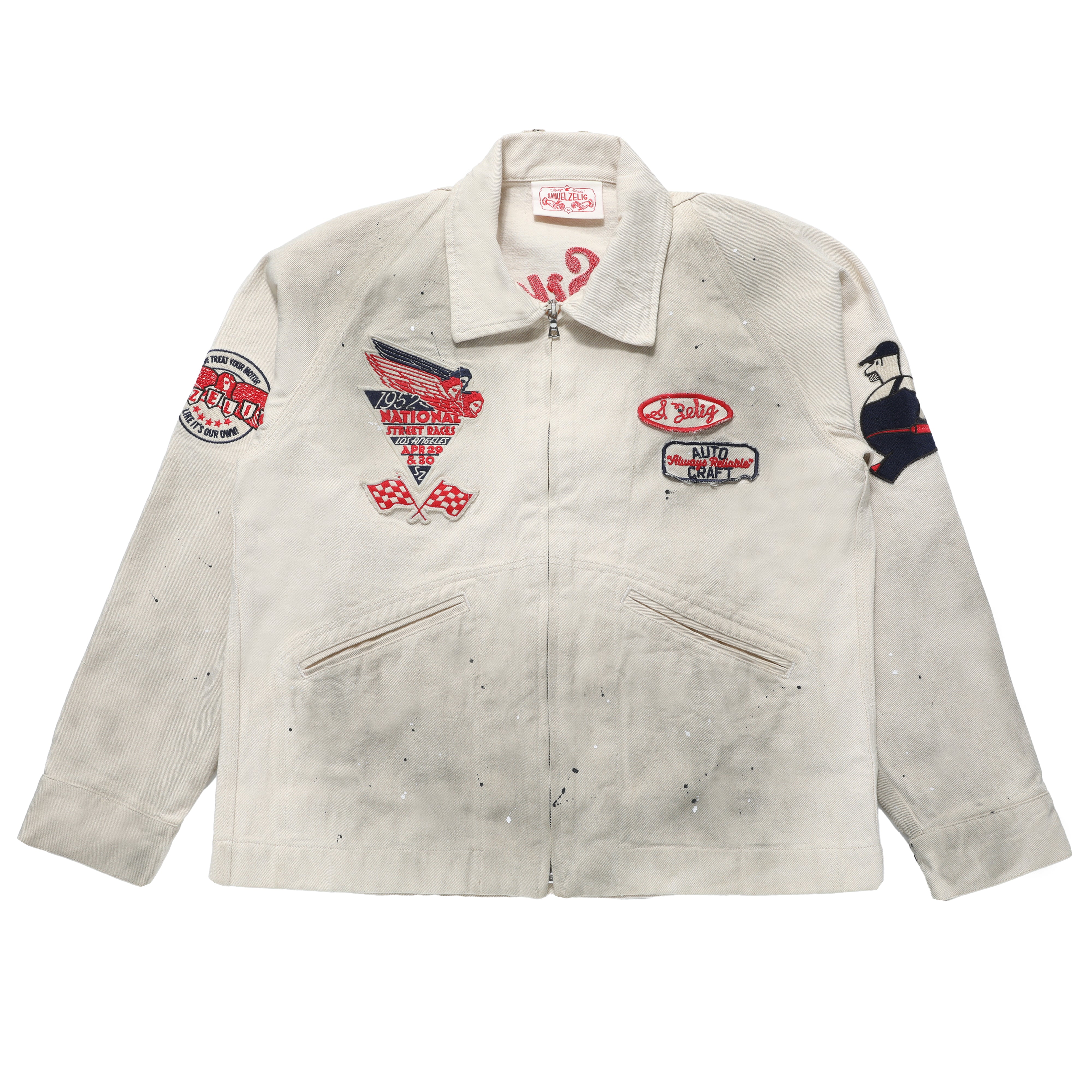 A vintage off-white canvas work jacket with multiple colorful embroidered patches on the chest and sleeves, featuring a front zipper and two zippered pockets.
