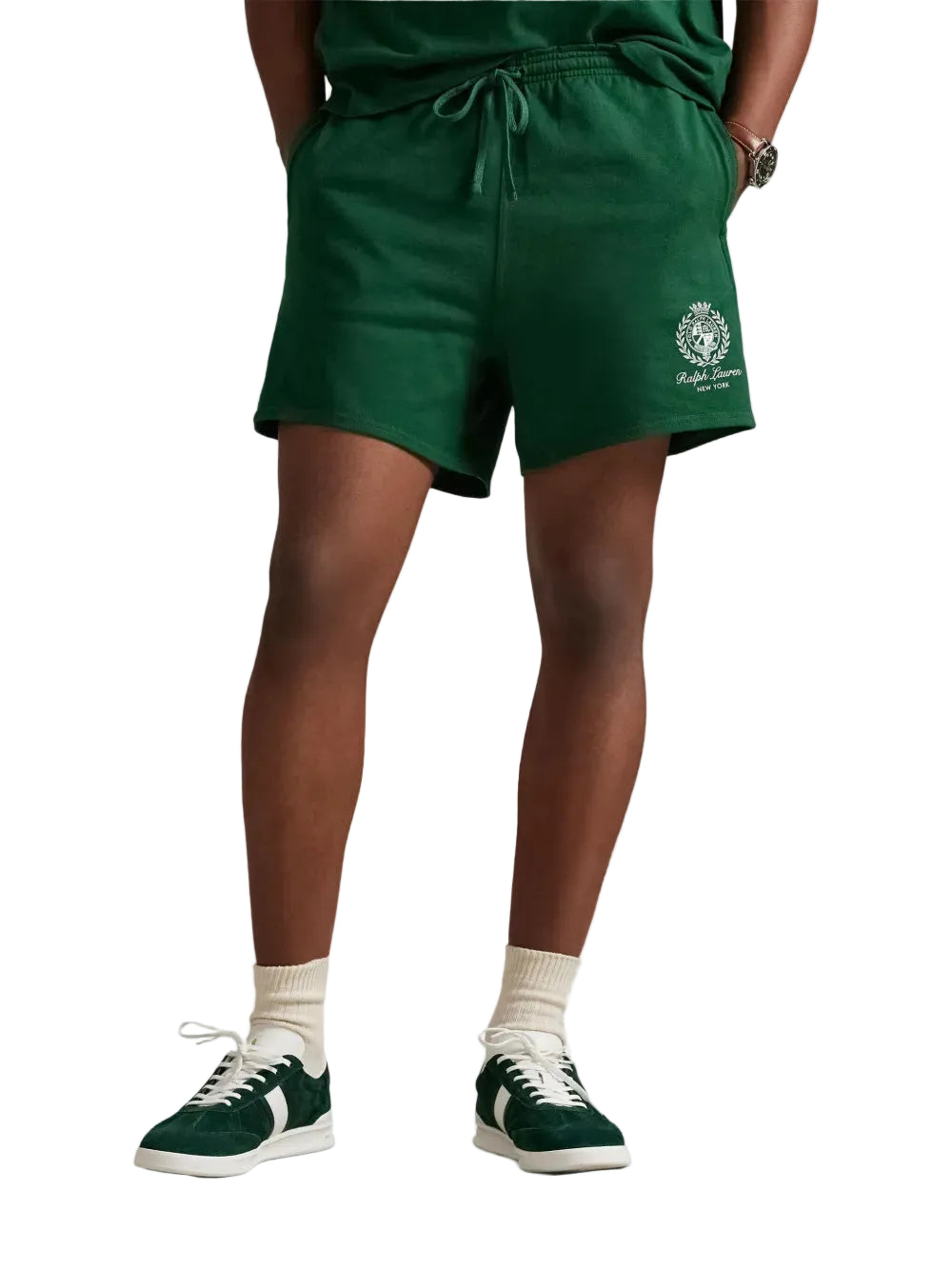 Person wearing green shorts with a logo on a white background