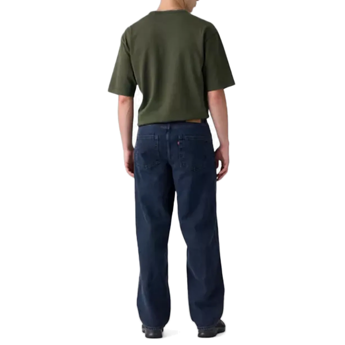 Back view of a model wearing dark indigo Levi’s 578 Baggy Jeans with an olive green T-shirt and black shoes, showing the baggy fit through the seat and the wide leg.