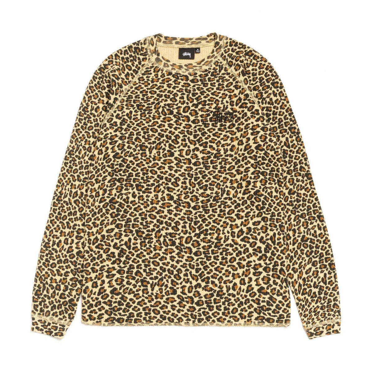 Front view of the Stüssy Basic Stüssy Thermal in leopard print laid flat. A long-sleeve waffle-knit top in a tan, black and rust leopard print with raglan sleeves and a small black Stüssy logo on the chest.