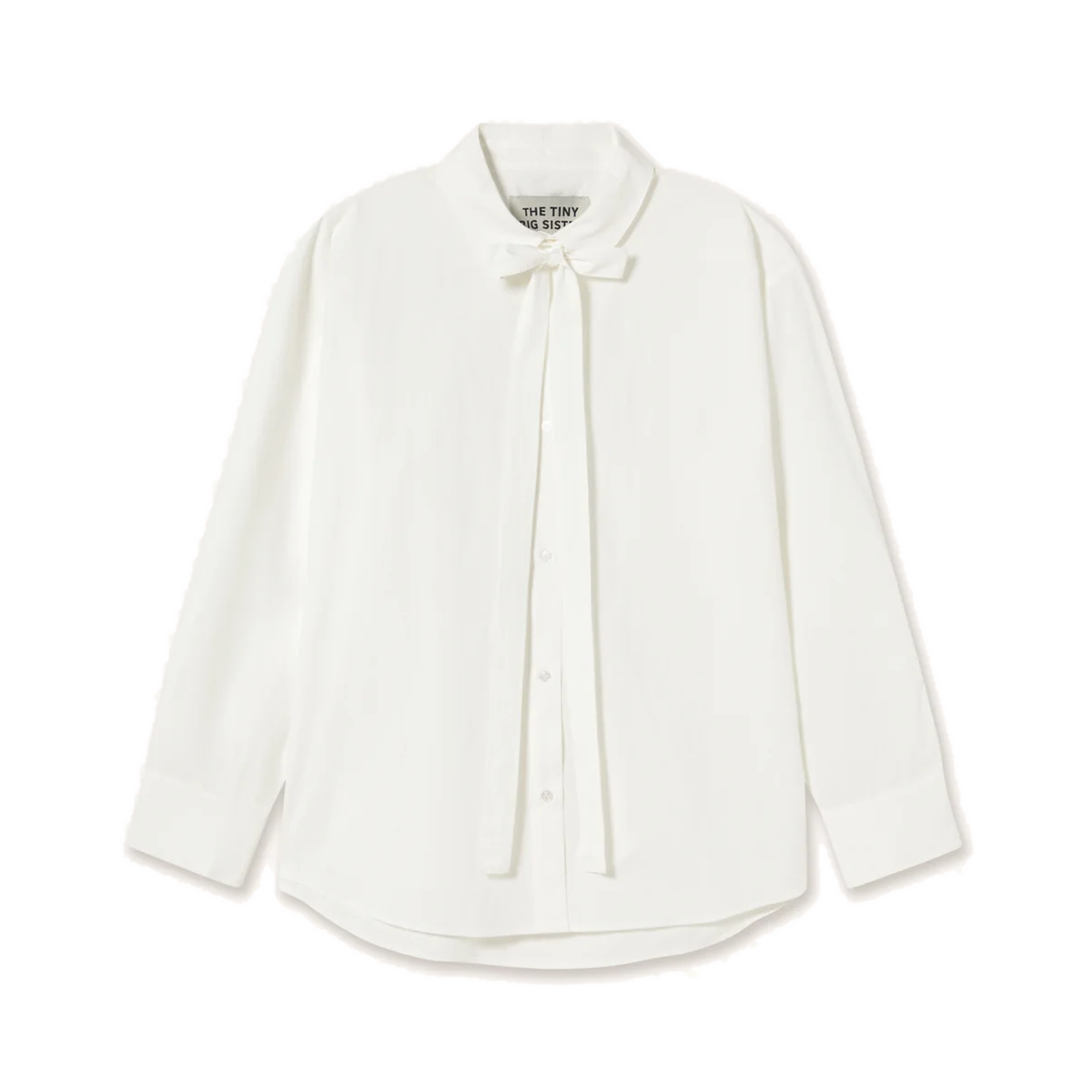Front view of The Tiny Big Sister Bow Neck Shirt in white, laid flat on white, showing the bow at the collar with long ties falling down the button front.