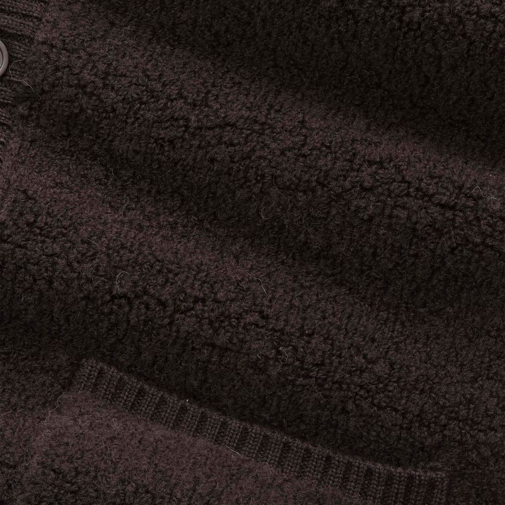 Close-up of a dark brown textured fleece with ribbed knit trim and a small button visible at the upper left.