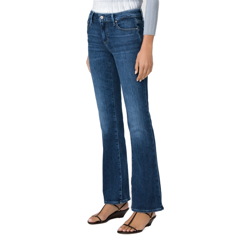 A model wearing a pair of medium-wash blue flare jeans, styled with a white ribbed top and black strappy sandals, shown from the waist down on a white background.