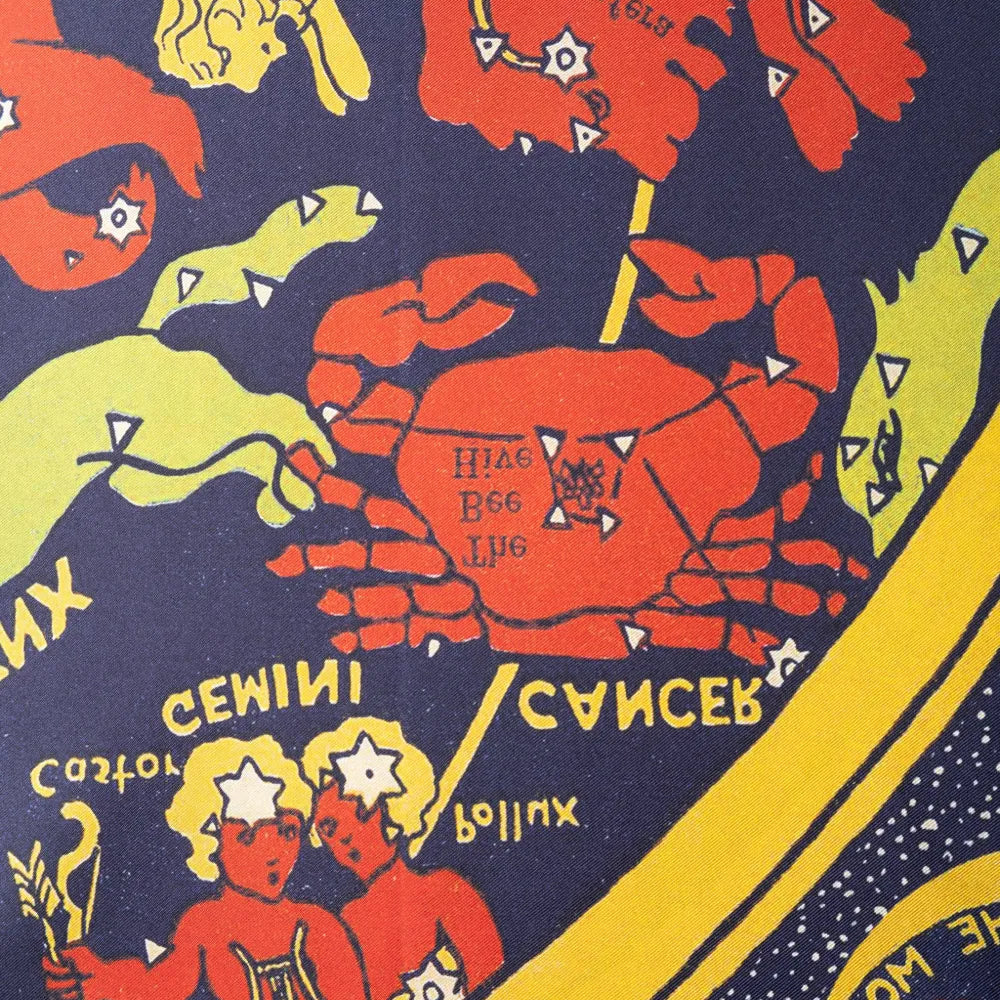 A close-up of a colorful astrological print featuring red crabs, yellow figures, and a dark navy background with text labels such as Gemini and Cancer.