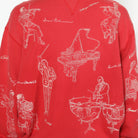 Red sweatshirt with white line art illustrations of musicians and musical instruments on a white background