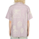 Person wearing a light purple shirt with white graphics on the back against a white background