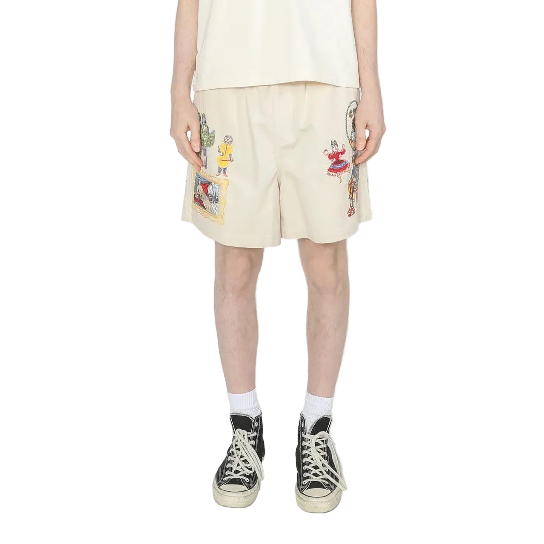 Person wearing a white t-shirt and beige shorts with colorful designs on a white background