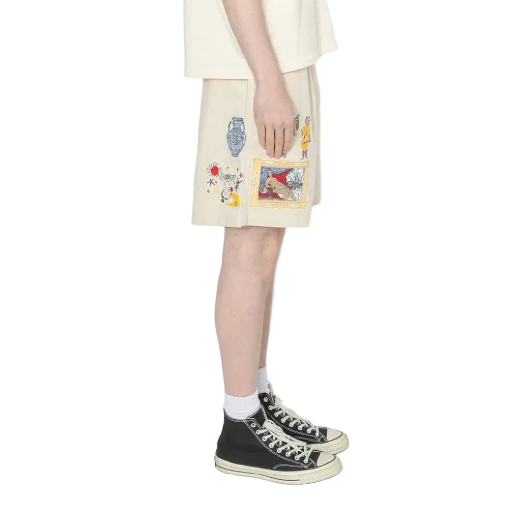 Person wearing a light-colored t-shirt and shorts with graphic designs on a white background
