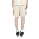 Person wearing a light-colored outfit with shorts and a t-shirt on a white background