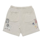 Beige shorts with various patches on a white background
