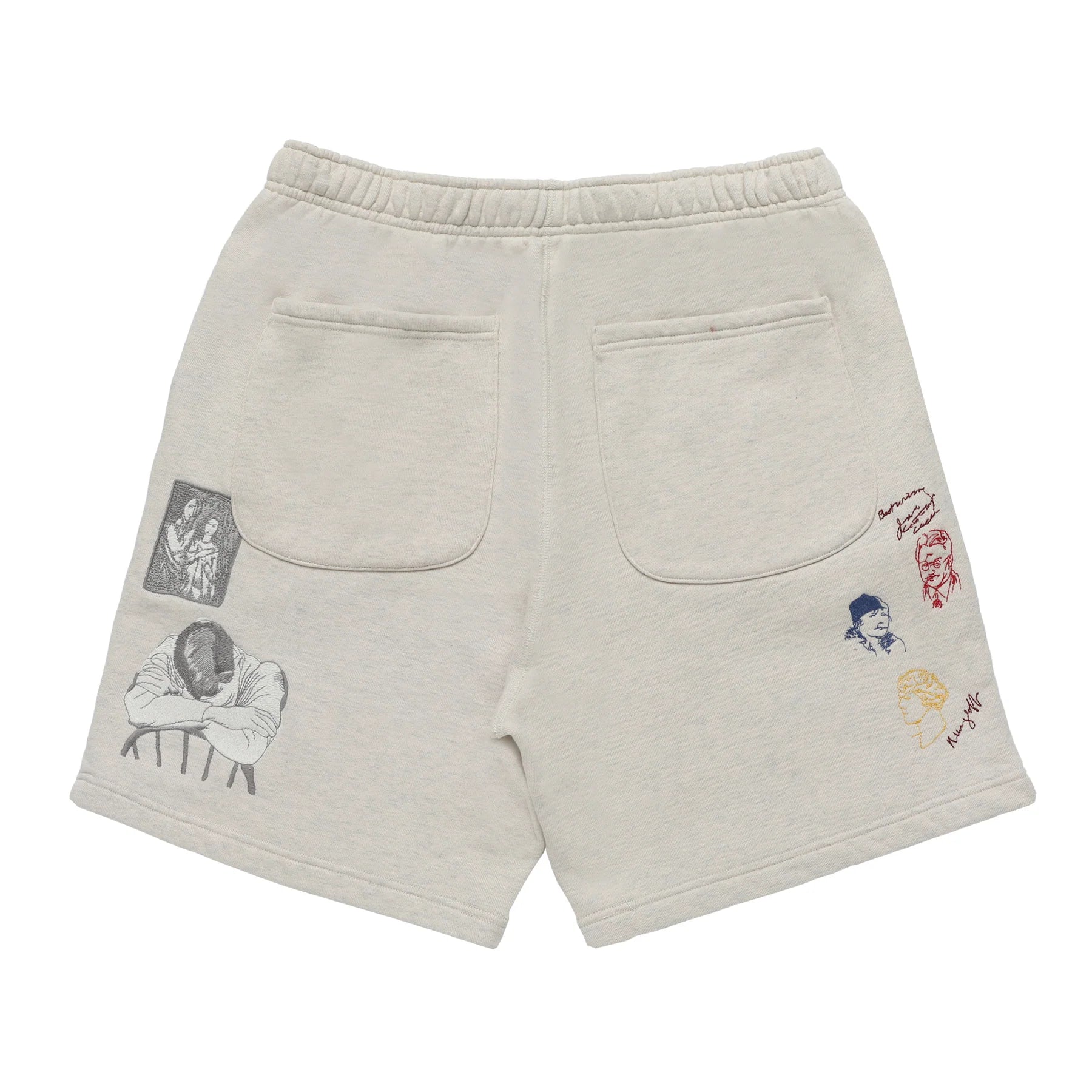Beige shorts with various patches on a white background