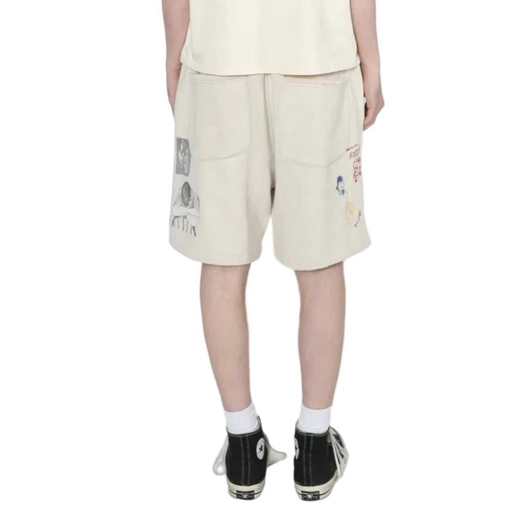 person wearing light grey shorts with embroidery designs on a white background