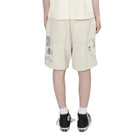 person wearing light grey shorts with embroidery designs on a white background