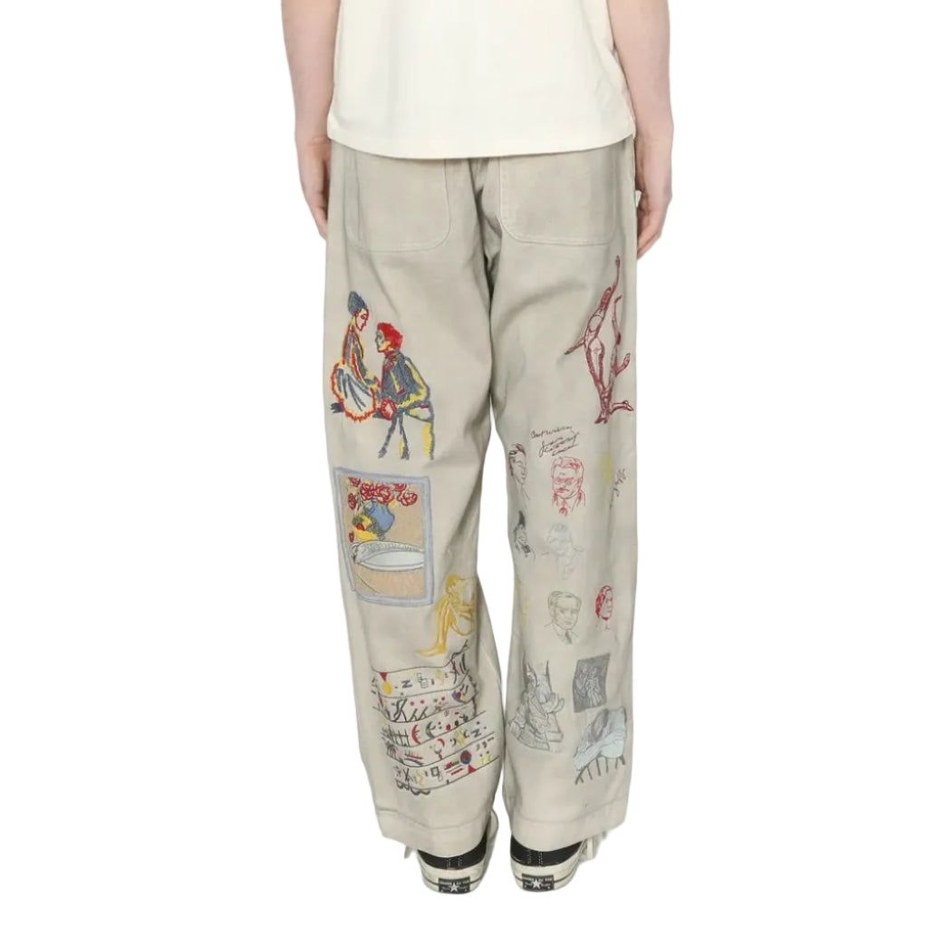 Person wearing a white t-shirt and patterned beige pants on a white background