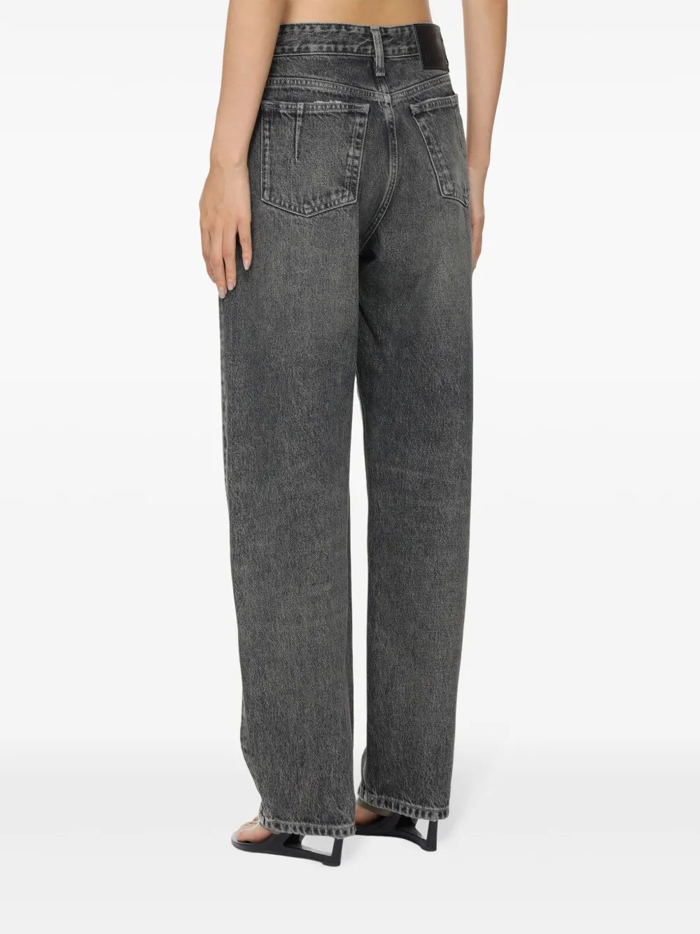 Person wearing high-waisted gray jeans on a white background