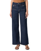 Person wearing dark blue wide-leg jeans on a white background