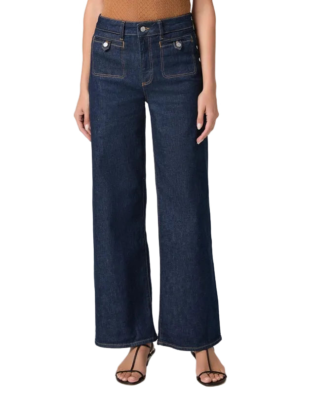 Person wearing dark blue wide-leg jeans on a white background
