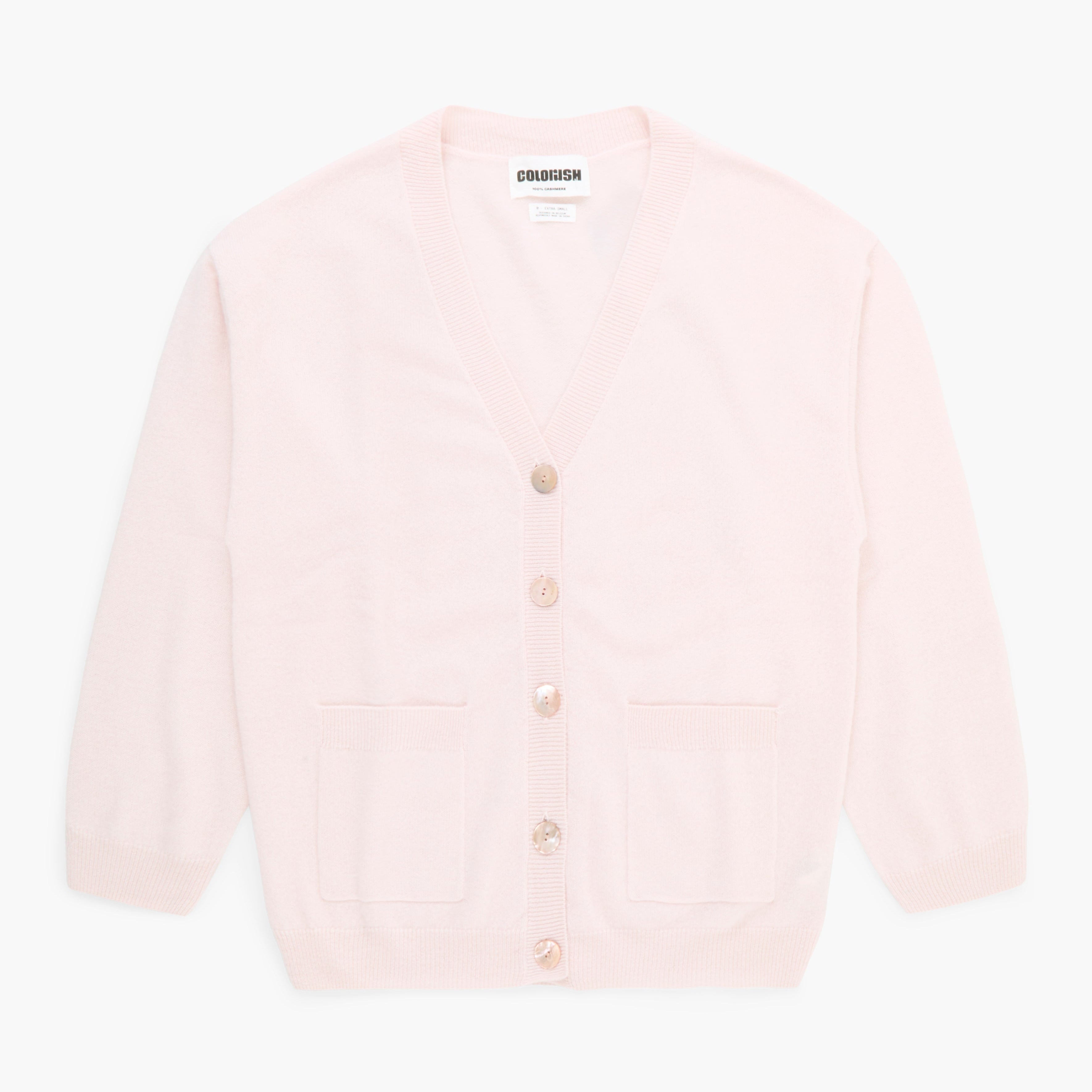 Light pink cardigan with gold buttons on a white background