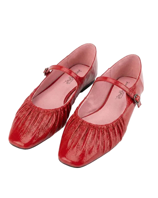 Pair of red shoes with a strap on a white background