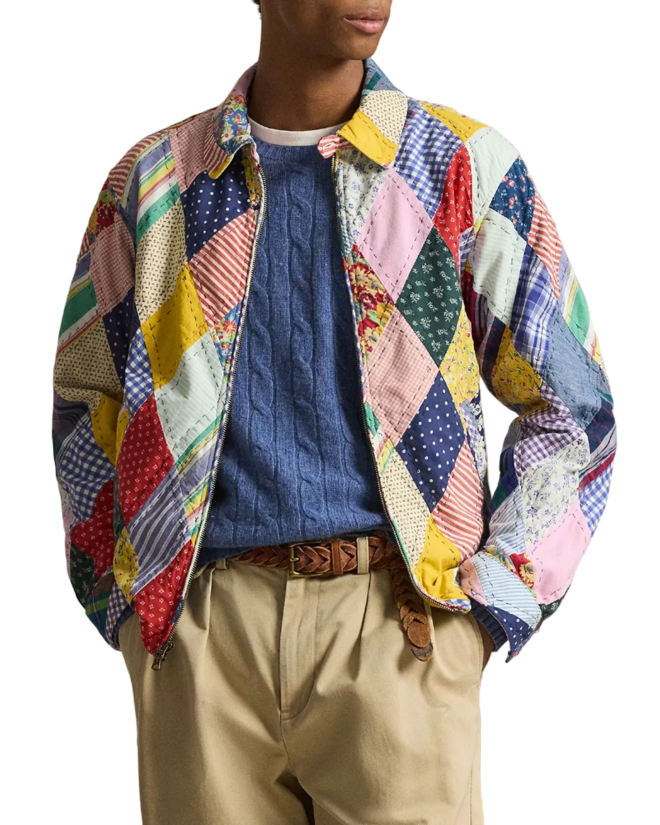 Person wearing a colorful patchwork jacket with a plain background