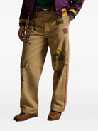 Beige pants with colorful embroidery on a white background