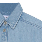 Close-up of a light blue denim shirt with collar and buttons on a white background