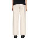 Person wearing beige wide-leg pants on a white background