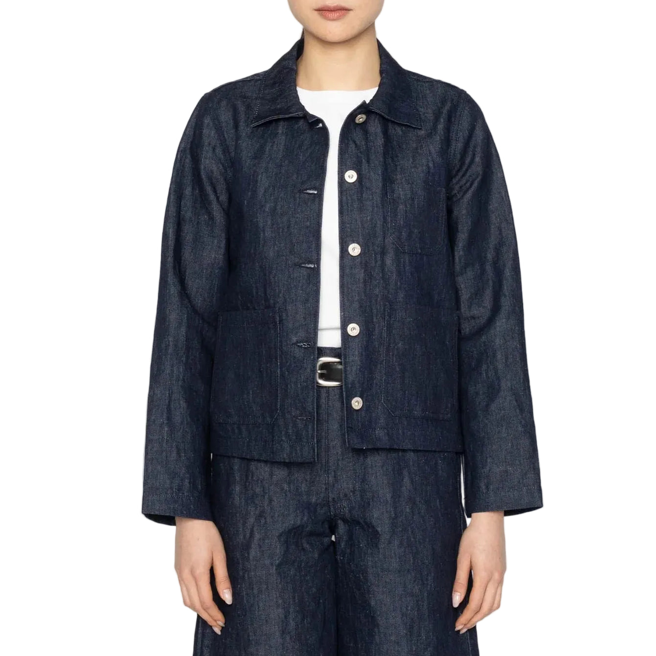 Person wearing a dark denim jacket and pants on a white background