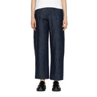 Person wearing dark blue wide-leg jeans on a white background