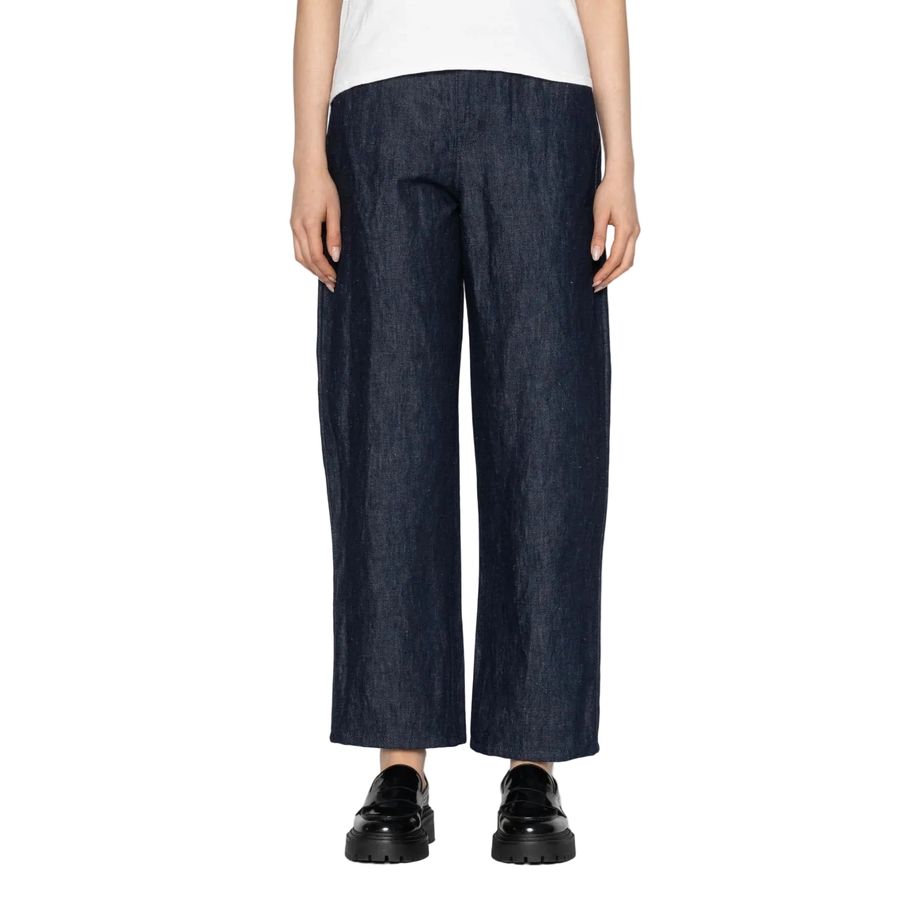 Person wearing dark blue wide-leg jeans on a white background