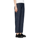 Person wearing dark blue wide-leg pants on a white background