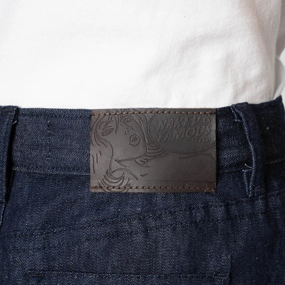 Close-up of a denim pocket with a brand label on a white background