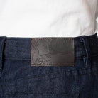 Close-up of a denim pocket with a brand label on a white background