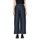 Person wearing dark blue wide-leg jeans on a white background