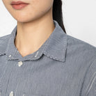 close-up of a person wearing a blue and white striped shirt with a point collar