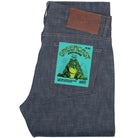 Blue denim jeans with a green graphic label featuring a frog on a white background