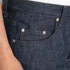 Close-up of dark blue denim jeans with stitching details.