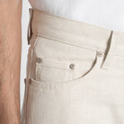 Close-up of beige pants with a white background