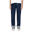 Person wearing dark blue jeans and black sneakers on a white background