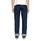 Person wearing dark blue jeans on a white background