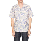 Man wearing a floral patterned shirt on a white background