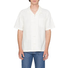 Person wearing a white shirt and blue jeans on a plain background