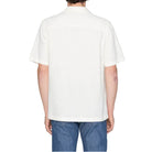 Person wearing a white shirt and blue jeans on a plain background