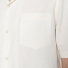 Close-up of a white shirt with buttons on a plain background