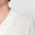 Close-up of a person wearing a white shirt with a blurred background