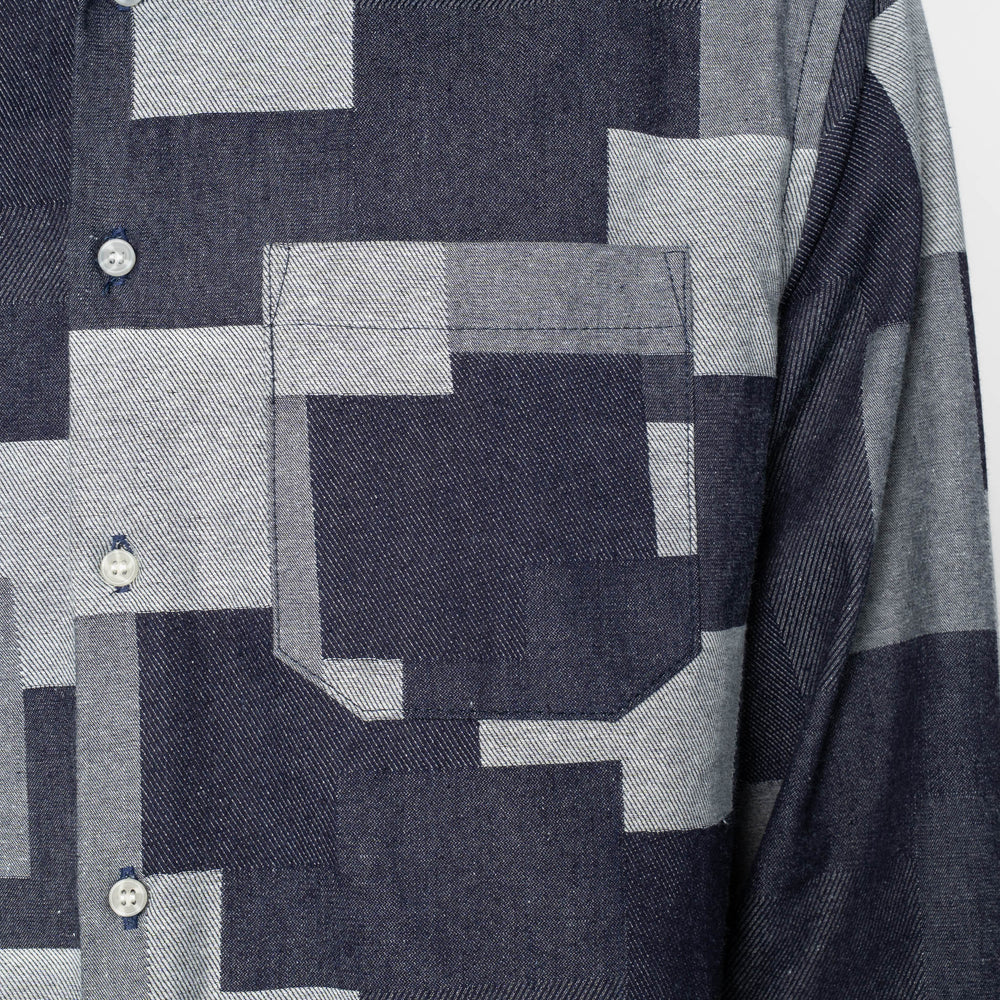 Close-up of a patterned shirt with geometric shapes in gray and blue.